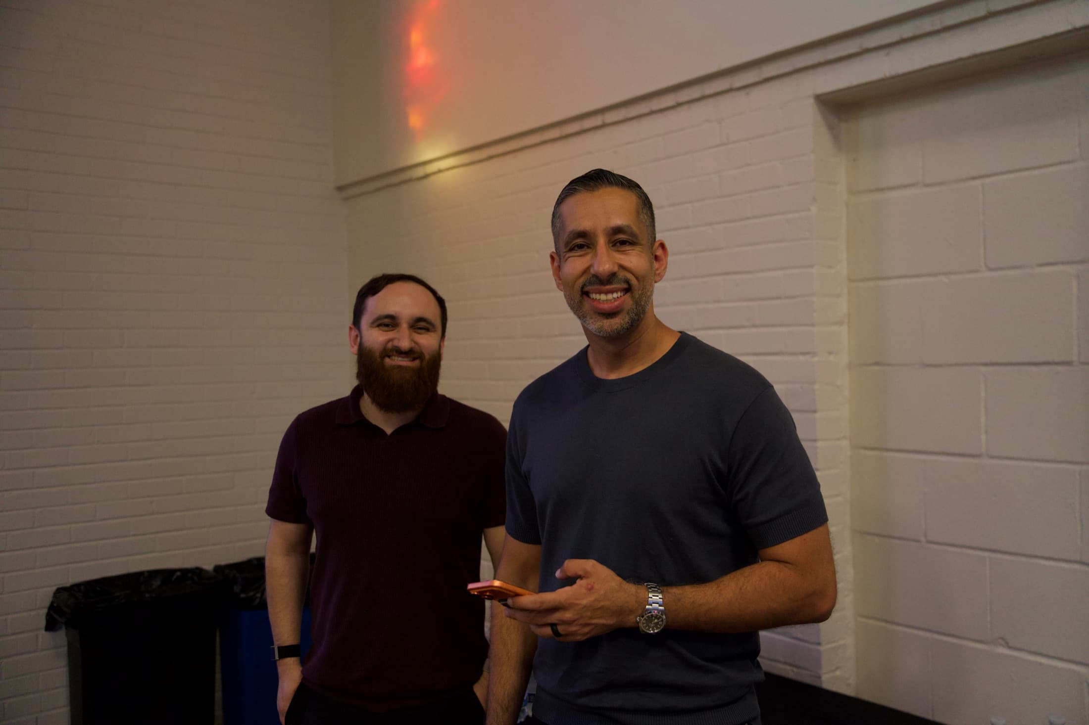 Two founders standing together, smiling at the camera