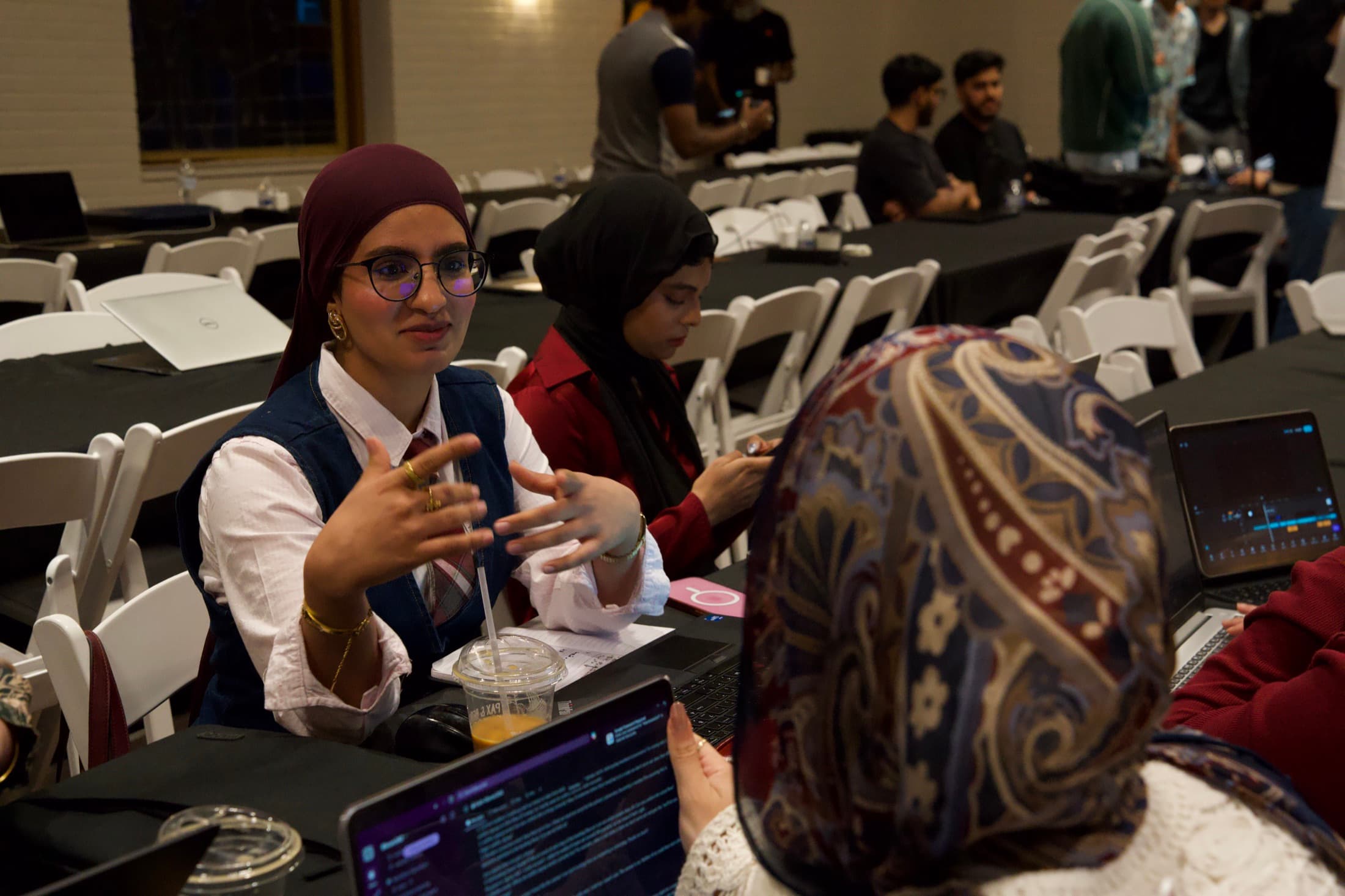A builder mid-story at her table, hands going