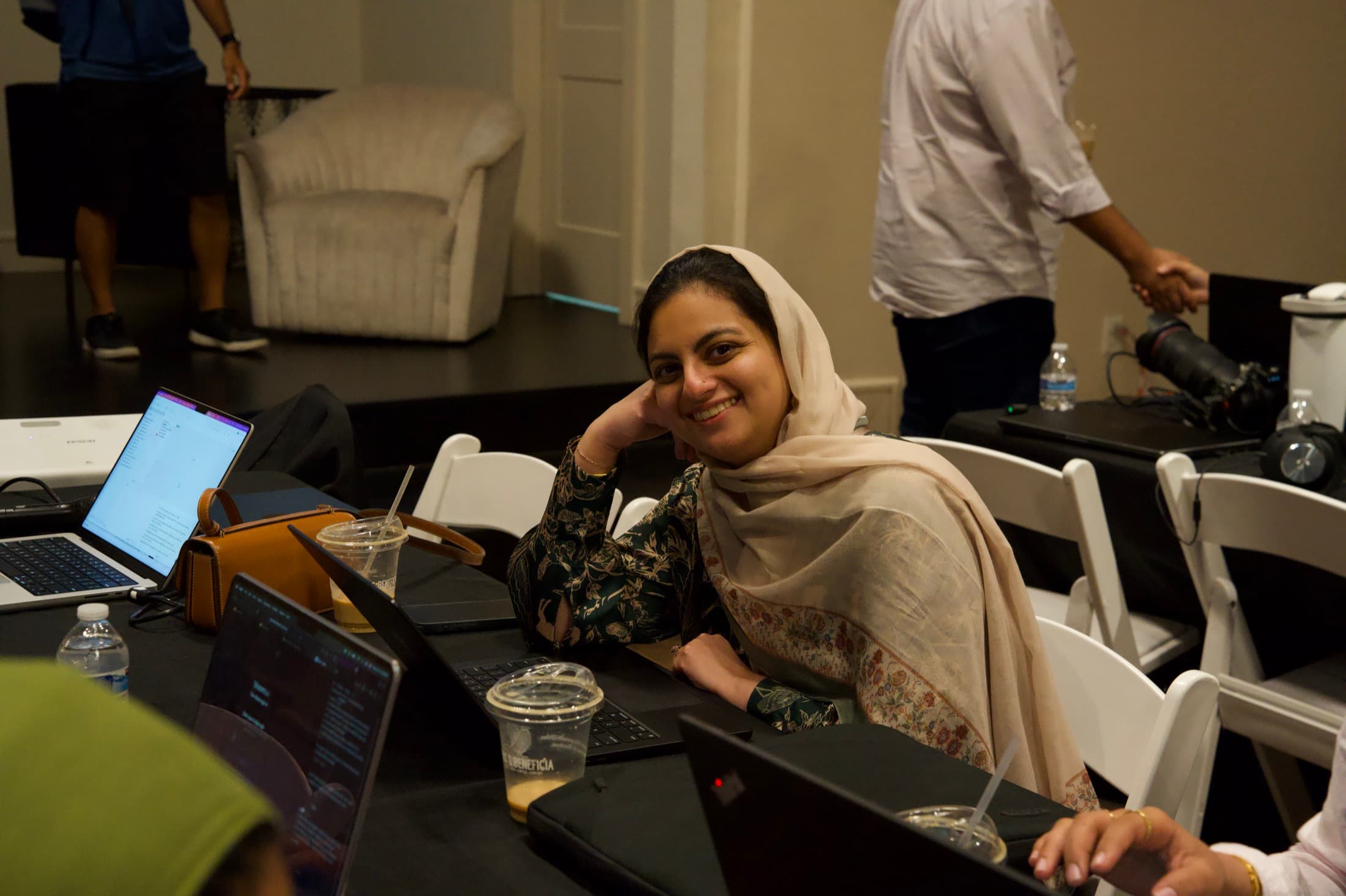 A builder smiling up from her laptop