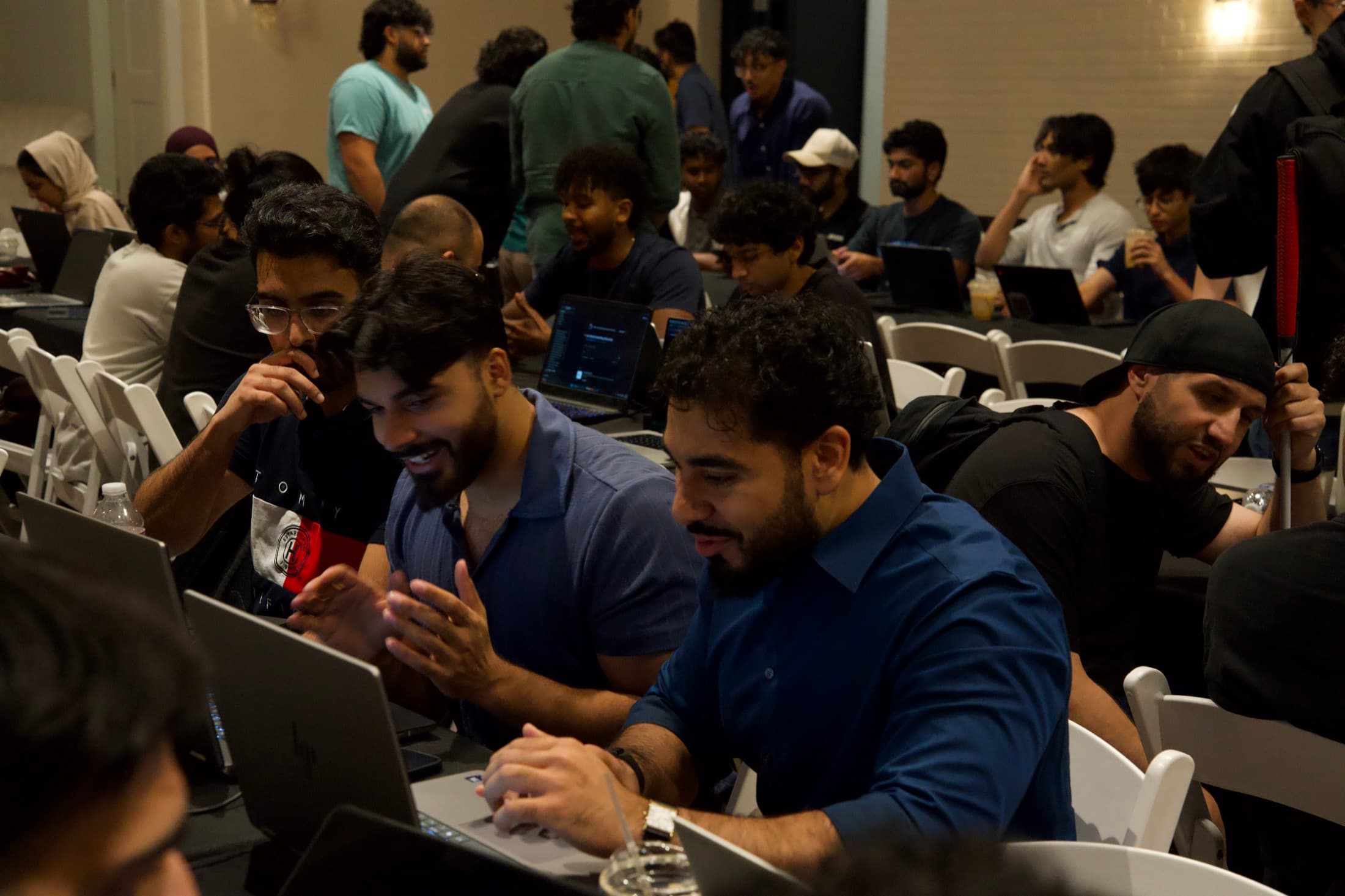 A packed table mid-discussion, laptops open between them
