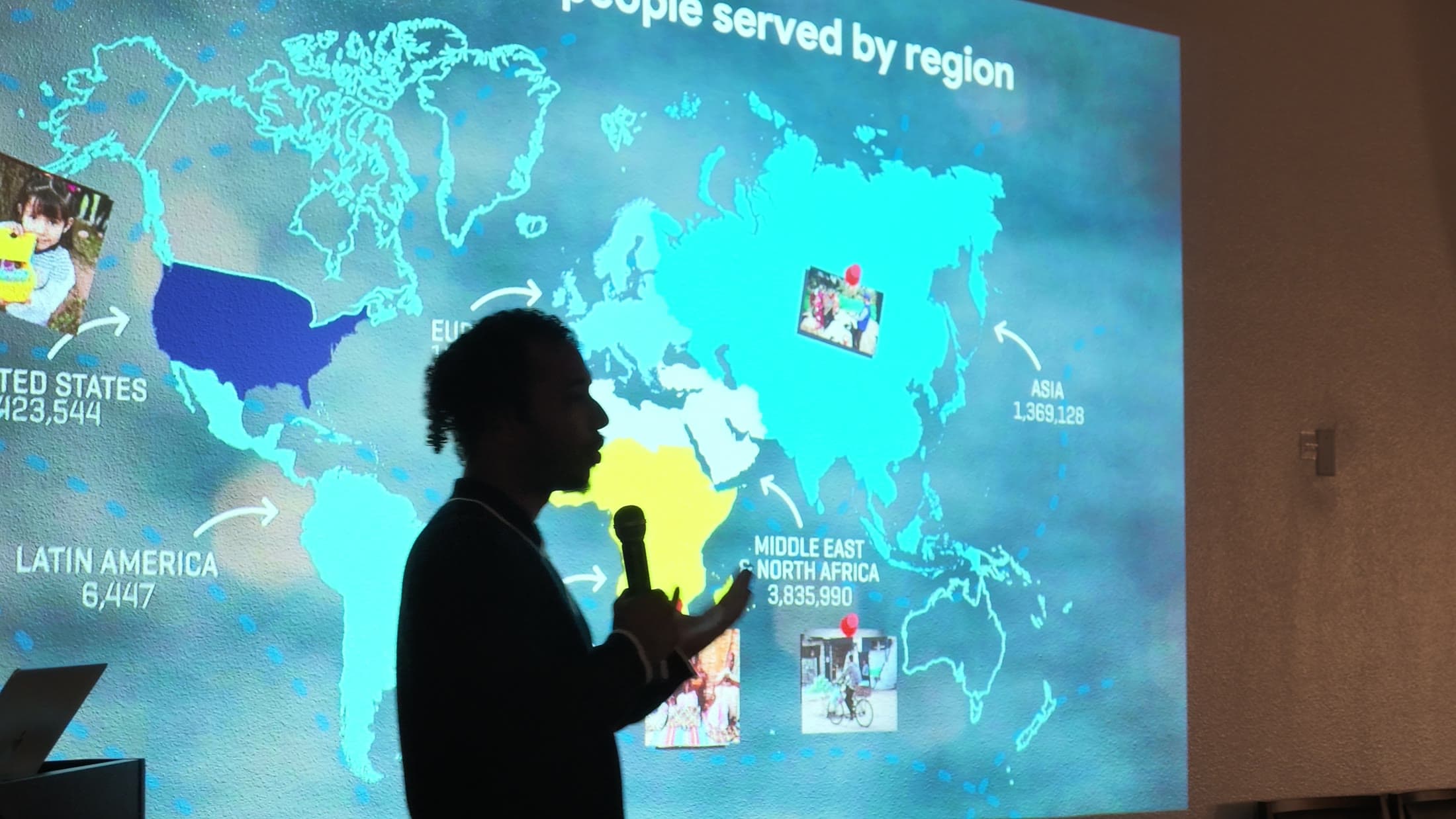 Tayseer Abubakar of IDEA, Islamic Development & Empowerment in America, in front of a map of the people IDEA serves
